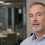 un homme en chemise bleue se tient dans un bureau