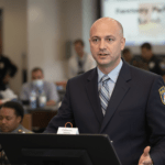 un homme debout devant un ordinateur portable